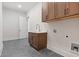 Well-lit laundry room with cabinets, sink, gray floor, and white walls at 101 Forsyth Park Ln, Woodstock, GA 30188