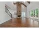 Bright open living room featuring soaring fireplace, hardwood floors, staircase, and outdoor access at 101 Forsyth Park Ln, Woodstock, GA 30188