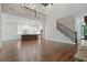 Expansive living room with hardwood floors, stone fireplace, staircase to loft, and views of the modern gourmet kitchen at 101 Forsyth Park Ln, Woodstock, GA 30188