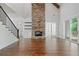 Sun-filled open living room boasts a soaring stone fireplace, hardwood floors, and access to the outdoors at 101 Forsyth Park Ln, Woodstock, GA 30188
