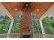 Outdoor fireplace with wooden beam, stone, wooden ceiling, and green trees at 101 Forsyth Park Ln, Woodstock, GA 30188