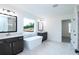 New bathroom with double vanities, soaking tub, framed mirrors, and a window at 1020 Cottonwood Ln, Loganville, GA 30052