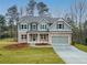 Charming two-story home featuring a brick facade, a covered porch, and a well-manicured lawn at 1020 Cottonwood Ln, Loganville, GA 30052