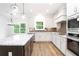 Bright kitchen with white cabinetry, granite countertops, and stainless appliances at 1020 Cottonwood Ln, Loganville, GA 30052