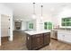Open kitchen with island, stainless appliances, and view to the living room at 1020 Cottonwood Ln, Loganville, GA 30052