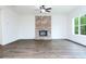 Bright living room features a brick fireplace, ceiling fan and large windows at 1020 Cottonwood Ln, Loganville, GA 30052
