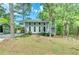 Charming two-story home with a well-maintained front yard and inviting curb appeal surrounded by mature trees at 6360 Ashdale Dr, Atlanta, GA 30349