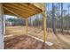 View of the backyard with wood deck underside and a large grassy area that backs up to a wooded area at 7256 Eton Ln, Locust Grove, GA 30248
