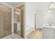 Modern bathroom featuring a glass shower, soaking tub, double vanity, and wood flooring at 7256 Eton Ln, Locust Grove, GA 30248