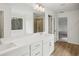 Bright bathroom with double sinks, modern lighting, and a view of the outdoors at 7256 Eton Ln, Locust Grove, GA 30248