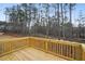 New wood deck with railings that overlooks a large wooded area at 7256 Eton Ln, Locust Grove, GA 30248