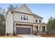 Charming two-story home with stone accents, gray siding, and a two car garage at 7256 Eton Ln, Locust Grove, GA 30248