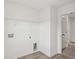 A laundry room with light wood flooring, white walls, and shelving at 7256 Eton Ln, Locust Grove, GA 30248