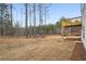 View of the backyard and a wooded area, with a wood deck on the side of the home at 7256 Eton Ln, Locust Grove, GA 30248