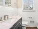 Bathroom with white tiled walls, granite countertop vanity, and dark gray cabinets at 2456 Colorado Sw Trl, Atlanta, GA 30331