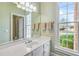 Bathroom with a sink, vanity, and large window overlooking the backyard at 5060 Rosedown Pl, Roswell, GA 30076