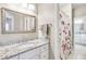 Bathroom with granite countertop, white cabinets, and floral shower curtain at 5060 Rosedown Pl, Roswell, GA 30076