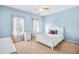 Light blue bedroom with a white bed, desk, and window seats at 5060 Rosedown Pl, Roswell, GA 30076