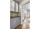 Gray butler's pantry with glass-front cabinets, granite countertop, and wood floors at 5060 Rosedown Pl, Roswell, GA 30076