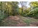 Spacious wooded backyard with scattered leaves on the ground at 116 Turman Se Ave, Atlanta, GA 30315