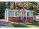 Charming single-story home with a brick foundation, light blue siding and a vibrant pink front door at 116 Turman Se Ave, Atlanta, GA 30315