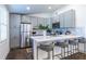 Open kitchen features a large island with seating, stainless steel appliances, and elegant gray cabinets at 116 Turman Se Ave, Atlanta, GA 30315