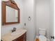 Powder room with vanity, toilet and decorative mirror at 5615 Forkwood Nw Dr, Acworth, GA 30101