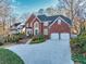 Red brick home with a three-car garage and manicured landscaping at 5615 Forkwood Nw Dr, Acworth, GA 30101
