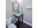 Modern bathroom with glass sink, dark vanity, and a white toilet at 605 Rose Creek Cir, Duluth, GA 30097