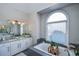 Elegant bathroom with granite countertops, a large soaking tub, and arched window at 605 Rose Creek Cir, Duluth, GA 30097