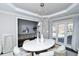 Sunlit dining room featuring an oval table, chandelier, and hardwood floors at 605 Rose Creek Cir, Duluth, GA 30097
