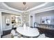 Elegant dining room with a white table, modern chandelier, and hardwood floors at 605 Rose Creek Cir, Duluth, GA 30097