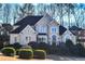 Two-story house with beige exterior, black roof, and manicured lawn at 605 Rose Creek Cir, Duluth, GA 30097