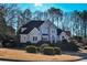 Two-story house with beige exterior, black roof, and manicured lawn at 605 Rose Creek Cir, Duluth, GA 30097