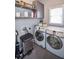 Bright laundry room with washer, dryer, and shelving at 605 Rose Creek Cir, Duluth, GA 30097