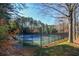 Two tennis courts with a fence in a wooded area at 605 Rose Creek Cir, Duluth, GA 30097