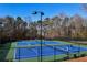 Two tennis courts with players and surrounding trees at 605 Rose Creek Cir, Duluth, GA 30097