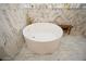 Freestanding soaking tub with marble tile in a luxurious bathroom at 1409 Sheridan Ne Rd, Atlanta, GA 30324