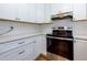 Modern kitchen featuring stainless steel range and white shaker cabinets at 242 Chads Ford Way, Roswell, GA 30076