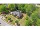 Aerial view of a red brick home with a gray roof, surrounded by lush greenery and mature landscaping at 1420 Arblay Pl, Loganville, GA 30052