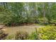 Landscaped backyard with mature trees and lush greenery at 1420 Arblay Pl, Loganville, GA 30052