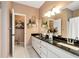 Bathroom features double sink vanity with granite countertop, neutral walls, and tile floors at 1420 Arblay Pl, Loganville, GA 30052