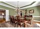 Elegant formal dining room featuring a large table, chandelier, and hardwood floors at 1420 Arblay Pl, Loganville, GA 30052