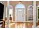 Elegant foyer with hardwood floors, decorative columns, arched windows and a stunning chandelier at 1420 Arblay Pl, Loganville, GA 30052