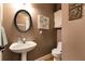 Elegant powder room featuring pedestal sink, decorative mirror and neutral color palette at 1420 Arblay Pl, Loganville, GA 30052