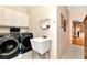 Convenient laundry room with washer, dryer, and utility sink at 1420 Arblay Pl, Loganville, GA 30052