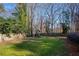 Fenced backyard with grassy area, playset, and mature trees at 6320 Bannerhorn Run, Alpharetta, GA 30005