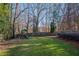 Fenced backyard with grassy area, playset, and mature trees at 6320 Bannerhorn Run, Alpharetta, GA 30005