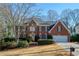 Brick two-story house with attached garage and landscaped yard at 6320 Bannerhorn Run, Alpharetta, GA 30005