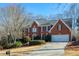 Brick two-story house with attached garage and manicured lawn at 6320 Bannerhorn Run, Alpharetta, GA 30005